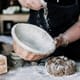 Banneton being dusted with flour