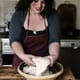Vanessa Kimbell teaching people at the table stretching dough and sharing how you make real sourdough bread