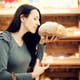 woman smelling loaf of freshly baked bread