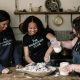 Two young women and Vanessa Kimbell mixing a bread dough.