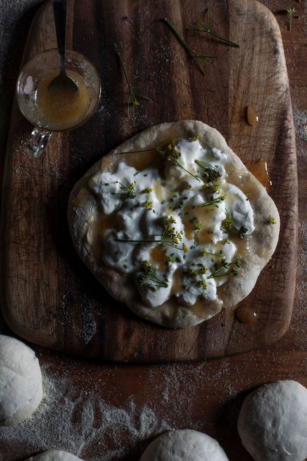 Pizza on a wooden board toppted with cheese and honey