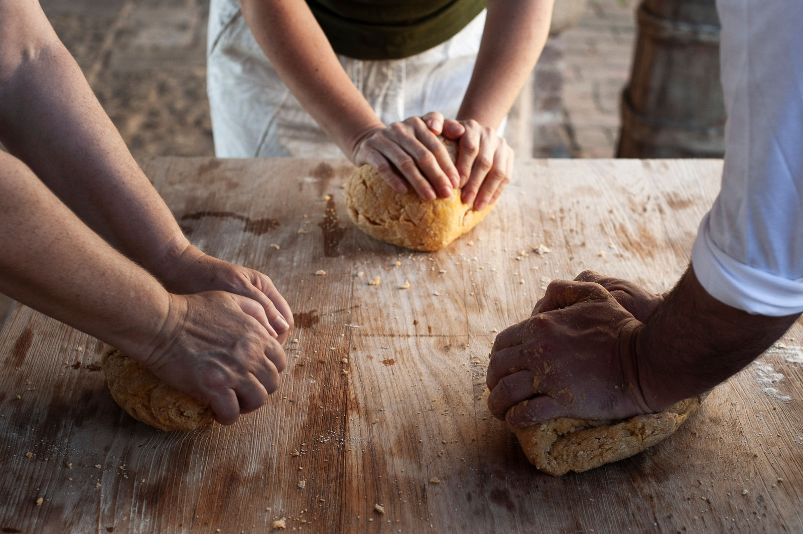 a group of peoples hands kneeding dough
